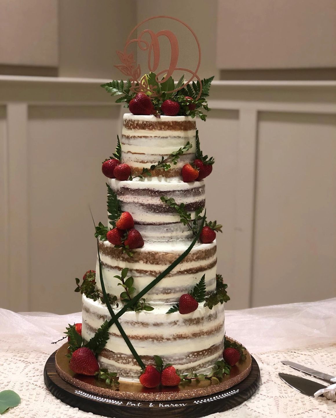 Naked wedding cake with fresh strawberries and greenery